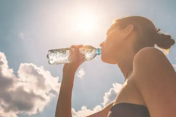 Hydration: The Secret Ingredient for a Toned Stomach and Enhanced Fitness 3 Image of woman drinking water to hydrate Bedfordshire after run.