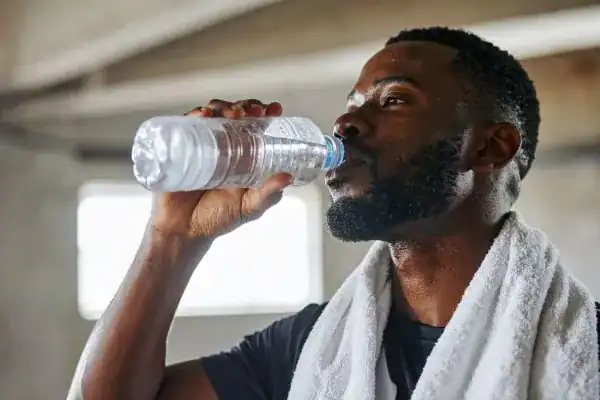 Image of man drinking water to improve hydration Bedfordshire after work out.
